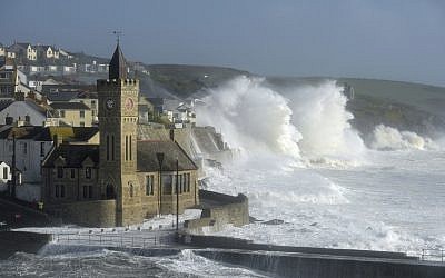 Waves break around the church in the harbor at Porthleven, Cornwall southwestern England, as the remnants of  Hurricane Ophelia begins to hit parts of Britain and Ireland. (Ben Birchall/PA via AP)