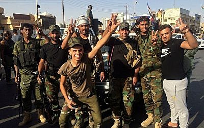 Iraqi security forces and volunteers celebrate in front of Governorate Council Building in Kirkuk, Iraq, October 16, 2017. (AP/Emad Matti)