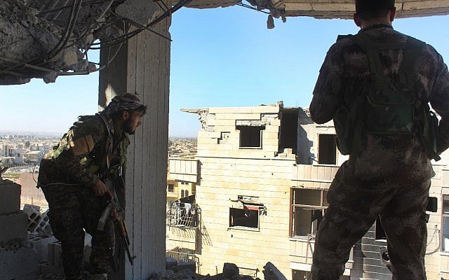 In this picture taken on Monday Oct. 16, 2017 and provided by The Syrian Democratic Forces (SDF), a U.S.-backed Syrian Kurdish forces outlet that is consistent with independent AP reporting, shows Syrian Democratic Forces (SDF) fighters, take their position on a destroyed building during their battle against the Islamic State militants, in Raqqa, Syria. (Syrian Democratic Forces, via AP) In this picture taken on Monday Oct. 16, 2017 and provided by The Syrian Democratic Forces (SDF), a U.S.-backed Syrian Kurdish forces outlet that is consistent with independent AP reporting, shows Syrian Democratic Forces (SDF) fighters, take their position on a destroyed building during their battle against the Islamic State militants, in Raqqa, Syria. (Syrian Democratic Forces, via AP)