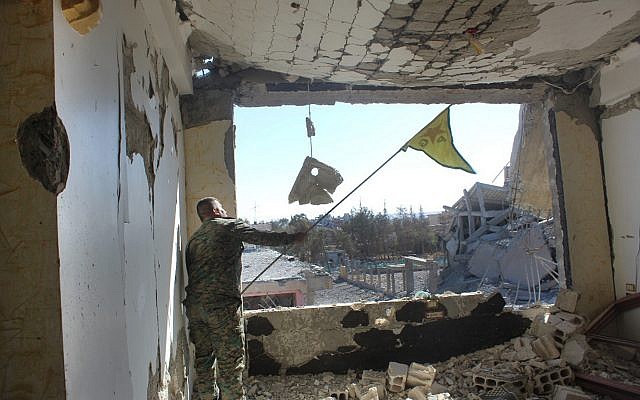 In this picture taken on Monday Oct. 16, 2017 and provided by The Syrian Democratic Forces (SDF), a U.S.-backed Syrian Kurdish forces outlet that is consistent with independent AP reporting, shows a Syrian Democratic Forces (SDF) fighter, waves his Kurdish party flag at the front line where they battle against the Islamic State militants, in Raqqa, Syria. The U.S-backed Syrian forces battling the Islamic State group in Syria say Raqqa's national hospital, one of the militants' last holdouts in city has been captured.(Syrian Democratic Forces via AP) In this picture taken on Monday Oct. 16, 2017 and provided by The Syrian Democratic Forces (SDF), a U.S.-backed Syrian Kurdish forces outlet that is consistent with independent AP reporting, shows a Syrian Democratic Forces (SDF) fighter, waves his Kurdish party flag at the front line where they battle against the Islamic State militants, in Raqqa, Syria. The U.S-backed Syrian forces battling the Islamic State group in Syria say Raqqa's national hospital, one of the militants' last holdouts in city has been captured.(Syrian Democratic Forces via AP)
