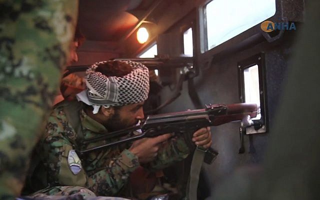 This frame grab from video released Tuesday October 17, 2017 and provided by Hawar News Agency, a Syrian Kurdish activist-run media group, shows a fighter from the U.S.-backed Syrian Democratic Forces (SDF) firing his weapon during clashes with Islamic State militants, in Raqqa, Syria. (Hawar News Agency via AP) This frame grab from video released Tuesday October 17, 2017 and provided by Hawar News Agency, a Syrian Kurdish activist-run media group, shows a fighter from the U.S.-backed Syrian Democratic Forces (SDF) firing his weapon during clashes with Islamic State militants, in Raqqa, Syria. (Hawar News Agency via AP)