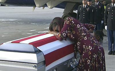 In this Tuesday, October 17, 2017, frame from video, Myeshia Johnson cries over the casket of her husband, Sgt. La David Johnson, who was killed in an ambush in Niger, upon his body's arrival in Miami. (WPLG via AP)