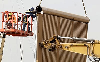 Crews work on a border wall prototype near the border with Tijuana, Mexico, Thursday, Oct. 19, 2017, in San Diego. Companies are nearing an Oct. 26 deadline to finish building eight prototypes of President Donald Trump's proposed border wall with Mexico. (AP Photo/Gregory Bull)