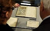 People look over a record book from 1836 that is displayed at the YIVO Institute for Jewish Research in New York, on October 24, 2017. (AP/Seth Wenig)