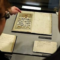 People look over a record book from 1836 that is displayed at the YIVO Institute for Jewish Research in New York, on October 24, 2017. (AP/Seth Wenig)