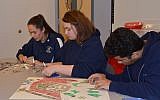 Foxborough Regional Charter School High school students selecting stamps to use on two HSP stamps collages, “I Am the Last Witness” and “Books Cannot Be Killed by Fire.” (Courtesy of Charlotte Sheer/Holocaust Stamp Project)
