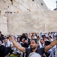 Illustrative: Jewish worshipers hold up the Torah scroll at the annual priestly blessing during the Sukkot holiday at the Western Wall in the Old City of Jerusalem on October 8, 2017. (Yonatan Sindel/Flash90) Illustrative: Jewish worshipers hold up the Torah scroll at the annual priestly blessing during the Sukkot holiday at the Western Wall in the Old City of Jerusalem on October 8, 2017. (Yonatan Sindel/Flash90)