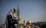 Illustrative: A Jewish worshiper holds the four plant species as he attends the annual priestly blessing during the Sukkot holiday at the Western Wall in the Old City of Jerusalem on October 8, 2017. (Yonatan Sindel/Flash90)