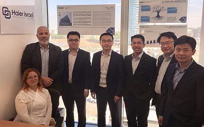 Galit Jacobovitz (sitting down, left) with Daniel Oleiski, left, standing, and with Wang Ye, third from left and the rest of the Haier delegation during their visit to Israel. Oct. 24, 2017. (Courtesy)