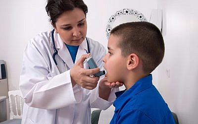 Doctor helping a boy with his asthma inhaler (LeventKonuk, iStock by Getty Images)