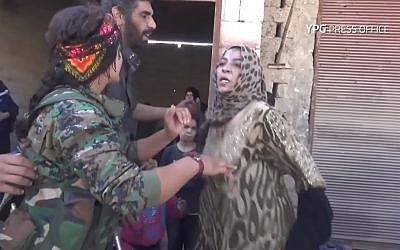 Woman rips off Islamic State-imposed black cloak in celebration, at liberation of Raqqa, October 13, 2017. (Screen capture: YouTube, YPG)