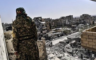 A member of the Syrian Democratic Forces (SDF), backed by US special forces, monitors the area on the western frontline in Raqqa on October 8, 2017. (AFP PHOTO / BULENT KILIC)
