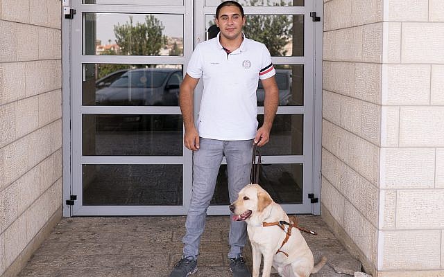 Saleem Sharif, with Winston, outside the health clinic in Nazareth where he works. (Luke Tress/Times of Israel)