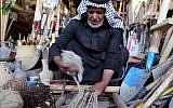 An Iraqi man weaves a carpet at his textile workshop in the Iraqi city of Hilla, south of Baghdad, on October 12, 2017. (AFP Photo/Sabah Arar)