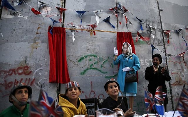 An actor dressed up as Queen Elizabeth and Palestinian children from the al-Ayda refugee camp attend an event organized by secretive British street artist Banksy to apologize for the 100th anniversary of the Balfour Declaration on November 1, 2017 at his Walled-Off Hotel in Bethlehem in the West Bank. (AFP/Ahmad Gharabli) An actor dressed up as Queen Elizabeth and Palestinian children from the al-Ayda refugee camp attend an event organized by secretive British street artist Banksy to apologize for the 100th anniversary of the Balfour Declaration on November 1, 2017 at his Walled-Off Hotel in Bethlehem in the West Bank. (AFP/Ahmad Gharabli)