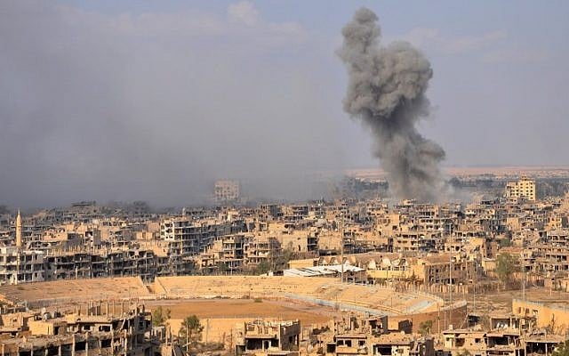 Illustrative: Smoke billows from the eastern city of Deir Ezzor during an operation by Syrian government forces against Islamic State (IS) group jihadists on November 2, 2017. (AFP/Stringer) Illustrative: Smoke billows from the eastern city of Deir Ezzor during an operation by Syrian government forces against Islamic State (IS) group jihadists on November 2, 2017. (AFP/Stringer)