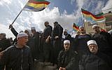 Druze men in the Israeli Golan Heights congregate near the Syrian border, waving their community's flag, after they heard about a suicide bombing in the Syrian Druze village of Hadar, on November 3, 2017. (Jalaa Marey/AFP)