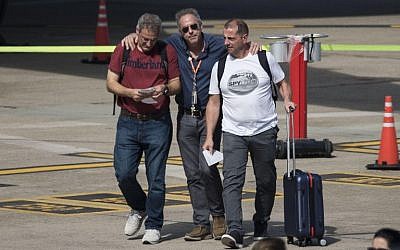 Argentine survivors of the recent New York bike path truck attack, Juan Pablo Trevisan (L) and Ariel Benvenuto (R), are greeted by an unidentified man upon their arrival in Rosario on November 6, 2017. (AFP Photo/STR)