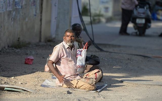 An Indian man begs on the side of the road in Hyderabad on November 10, 2017. (AFP PHOTO / NOAH SEELAM)