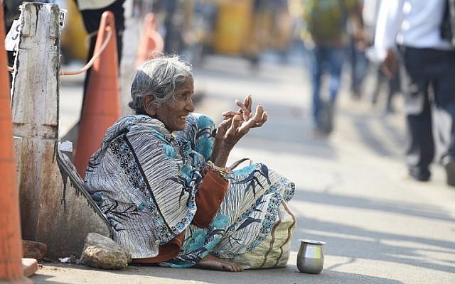 An Indian woman begs on the side of the road in Hyderabad on November 10, 2017.
(AFP PHOTO / NOAH SEELAM)