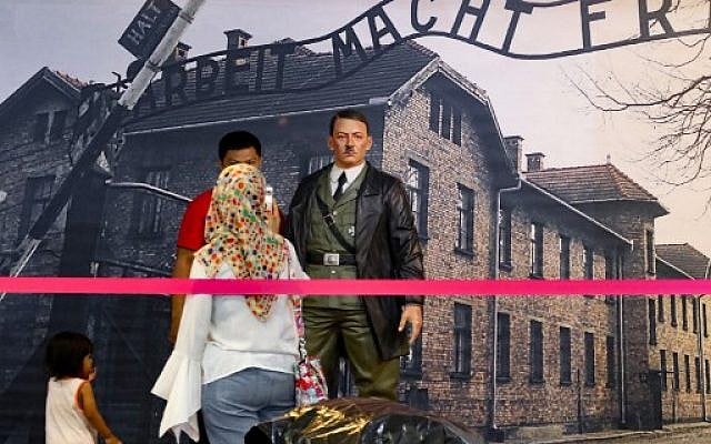 This photograph taken on November 10, 2017 shows an Indonesian family preparing to take a photograph with a life-size wax sculpture of Adolf Hitler at a museum in Yogyakarta (AFP / HENRYANTO) This photograph taken on November 10, 2017 shows an Indonesian family preparing to take a photograph with a life-size wax sculpture of Adolf Hitler at a museum in Yogyakarta (AFP / HENRYANTO)