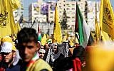 Fatah supporters wave the party flag as they take part in a rally in Gaza City on November 11, 2017(AFP/MAHMUD HAMS)