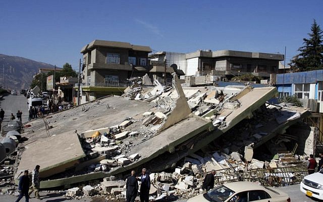 People gather around a levelled building in the mountainous town of Darbandikhan in Iraqi Kurdistan on November 13, 2017, following a 7.3-magnitude quake that hit the Iraq-Iran border area. (AFP PHOTO / SHWAN MOHAMMED) People gather around a levelled building in the mountainous town of Darbandikhan in Iraqi Kurdistan on November 13, 2017, following a 7.3-magnitude quake that hit the Iraq-Iran border area. (AFP PHOTO / SHWAN MOHAMMED)
