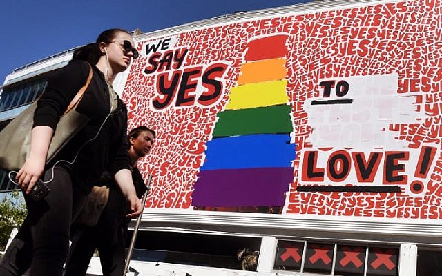 People walk past a giant billboard promoting the "yes" vote for same-sex marriage in Sydney's Kings Cross district on November 14, 2017. (AFP PHOTO / William WEST) People walk past a giant billboard promoting the "yes" vote for same-sex marriage in Sydney's Kings Cross district on November 14, 2017. (AFP PHOTO / William WEST)