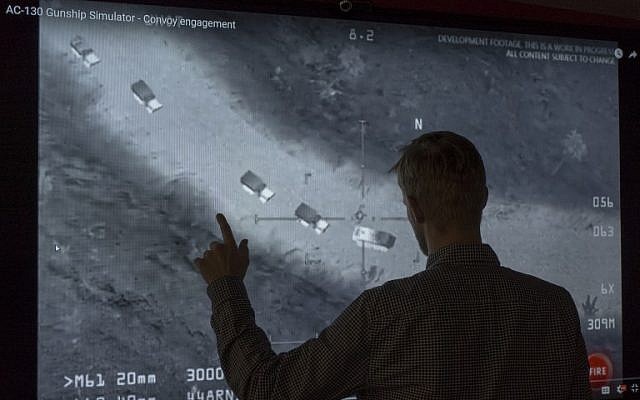 In this November 14, 2017, photo illustration a journalist in Washington, DC, looks at YouTube video showing images from a aerial assault video game. Russia's defense ministry on Tuesday shared the same footage on its own channels saying it proved the US was aiding the Islamic State in the Middle East, but social media users pointed out they included a still from a video game. (AFP Photo/STF) In this November 14, 2017, photo illustration a journalist in Washington, DC, looks at YouTube video showing images from a aerial assault video game. Russia's defense ministry on Tuesday shared the same footage on its own channels saying it proved the US was aiding the Islamic State in the Middle East, but social media users pointed out they included a still from a video game. (AFP Photo/STF)