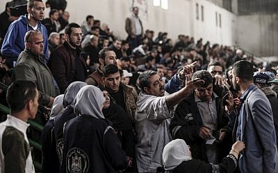 Palestinians argue with Hamas officials and security forces in a makeshift station at a basketball court in Khan Younis in the southern Gaza strip on November 18, 2017 as they await clearance to take a bus to travel through the Rafah border crossing with Egypt. (AFP/Mahmud Hams)