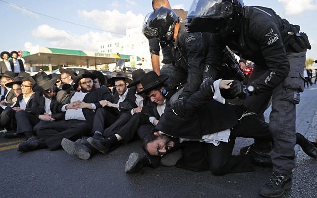 Police carry away ultra-Orthodox Jewish demonstrators as they disperse a protest against army conscription in the city of Bnei Brak, November 20, 2017. (AFP/Ahmad Gharabli) Police carry away ultra-Orthodox Jewish demonstrators as they disperse a protest against army conscription in the city of Bnei Brak, November 20, 2017. (AFP/Ahmad Gharabli)