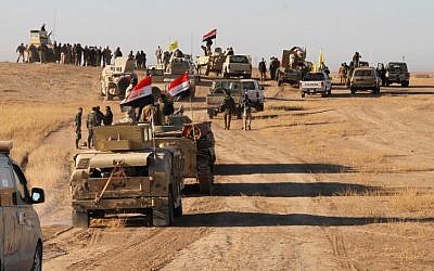 Iraqi forces, supported by members of the Hashed al-Shaabi (Popular Mobilization units), advance in the western desert in the northern Iraqi region of al-Hadar, 105 kilometers south of Mosul, on November 23, 2017, as they attempt to flush out remaining Islamic State group fighters (AFP/Stringer)
