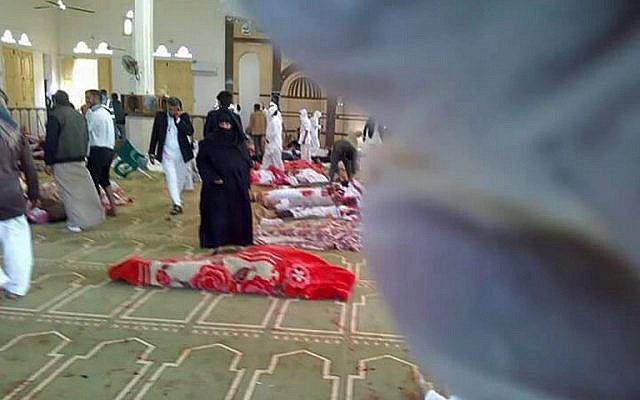 Egyptians gather around bodies following a gun and bombing attack at the Rawda mosque, roughly 40 kilometers west of the North Sinai capital of El-Arish, on November 24, 2017. (AFP PHOTO / STRINGER)