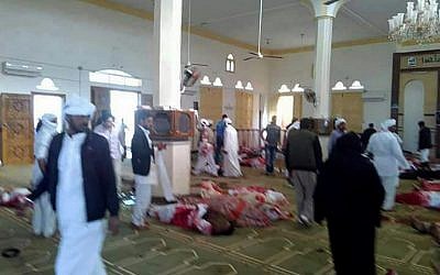 Egyptians walk past bodies following a gun and bombing terror attack at the Rawdah mosque, roughly 40 kilometers west of the North Sinai capital of El-Arish, on November 24, 2017. (AFP PHOTO / STRINGER)