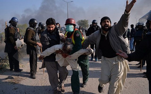 An injured activist from the Tehreek-i-Labaik Yah Rasool Allah Pakistan (TLYRAP) religious group is carried away from clashes with police in Islamabad on November 25, 2017.   (AFP PHOTO / AAMIR QURESHI)