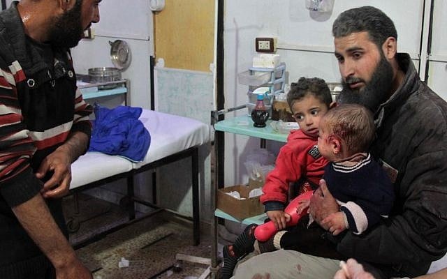 A Syrian man carrying two children awaits for medical attention at a makeshift clinic following a reported airstrike by Syrian government forces, in the rebel-held town of Douma in Syria's eastern Ghouta region, on November 26, 2017. (AFP PHOTO / Hamza Al-Ajweh) A Syrian man carrying two children awaits for medical attention at a makeshift clinic following a reported airstrike by Syrian government forces, in the rebel-held town of Douma in Syria's eastern Ghouta region, on November 26, 2017. (AFP PHOTO / Hamza Al-Ajweh)