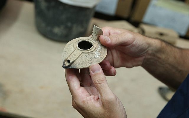 An intact oil lamp from the Abbasid period decorated with grape clusters and birds found in Jerusalem's City of David excavation, November 2017. (Eliyahu Yannai, courtesy of the City of David)