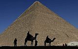 In this photo from December 12, 2012, policemen are silhouetted against the Great Pyramid in Giza, Egypt. (AP Photo/Hassan Ammar)