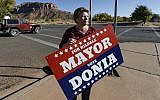 In this October 26, 2017 photo, Donia Jessop holds her mayoral campaign sign outside her store in Colorado City, Ariz. (AP Photo/Rick Bowmer)