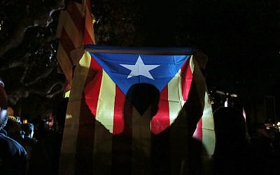 A man holds a 'Estelada', the pro-independence Catalan flag, as demonstrators gather outside the Catalonian Parliament to protest against the decision of a judge to jail ex-members of the Catalan government, in Barcelona, Spain, Thursday, November 2, 2017. (AP Photo/Manu Fernandez)