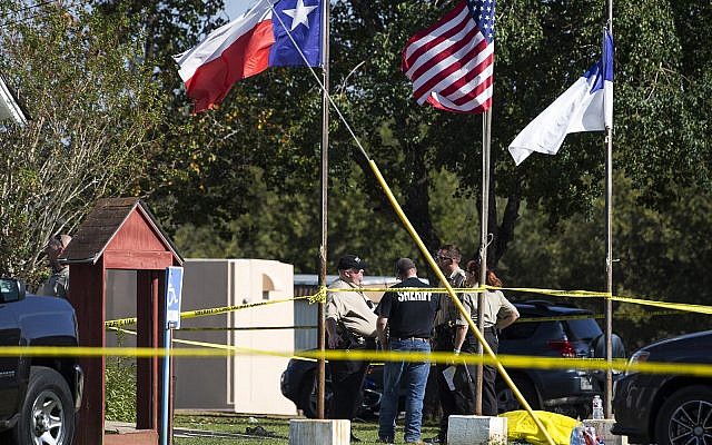 Law enforcement officials stand next to a covered body at the scene of a fatal shooting at the First Baptist Church in Sutherland Springs, Texas, on November 5, 2017. (Nick Wagner/Austin American-Statesman via AP) Law enforcement officials stand next to a covered body at the scene of a fatal shooting at the First Baptist Church in Sutherland Springs, Texas, on November 5, 2017. (Nick Wagner/Austin American-Statesman via AP)