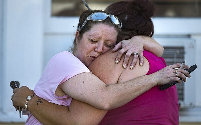 Carrie Matula embraces a woman after a fatal shooting at the First Baptist Church in Sutherland Springs, Texas, on November 5, 2017. (Nick Wagner/Austin American-Statesman via AP) Carrie Matula embraces a woman after a fatal shooting at the First Baptist Church in Sutherland Springs, Texas, on November 5, 2017. (Nick Wagner/Austin American-Statesman via AP)