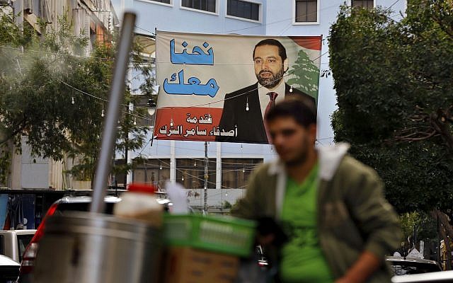 A street vendor stands in front of a poster of outgoing Prime Minister Saad Hariri, saying 'We are with you,' in Beirut, Lebanon, November 6, 2017. (AP Photo/Bilal Hussein) A street vendor stands in front of a poster of outgoing Prime Minister Saad Hariri, saying 'We are with you,' in Beirut, Lebanon, November 6, 2017. (AP Photo/Bilal Hussein)