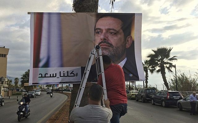 Workers hang a poster of outgoing Prime Minister Saad Hariri with Arabic words that read, "We are all Saad," on a seaside street in Beirut, Lebanon, November 9, 2017. (AP/ Hussein Malla) Workers hang a poster of outgoing Prime Minister Saad Hariri with Arabic words that read, "We are all Saad," on a seaside street in Beirut, Lebanon, November 9, 2017. (AP/ Hussein Malla)