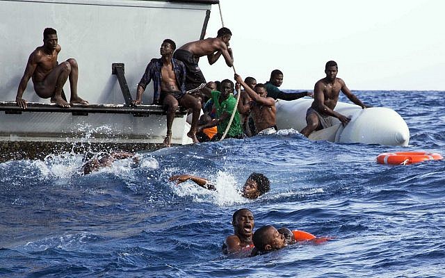 Migrants from a sinking inflatable dinghy try to board a Libyan coast guard ship during a rescue operation at sea in international waters off the coast of Libya on November 6, 2017. (Lisa Hoffmann/Sea-Watch via AP) Migrants from a sinking inflatable dinghy try to board a Libyan coast guard ship during a rescue operation at sea in international waters off the coast of Libya on November 6, 2017. (Lisa Hoffmann/Sea-Watch via AP)