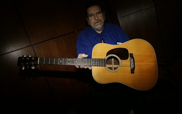 Garry Shrum, a music memorabilia specialist at Heritage Auctions, displays an acoustic guitar that belonged to Bob Dylan in Dallas, on October 13, 2017. (AP Photo/LM Otero) Garry Shrum, a music memorabilia specialist at Heritage Auctions, displays an acoustic guitar that belonged to Bob Dylan in Dallas, on October 13, 2017. (AP Photo/LM Otero)