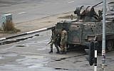 A military armored personnel carrier is seen with armed soldiers on the road leading to President Robert Mugabe's office in Harare, Zimbabwe Wednesday, Nov. 15, 2017. (AP Photo/Tsvangirayi Mukwazhi)