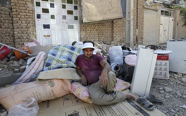 An earthquake survivor sits next to his belongings, which were recovered from debris in Sarpol-e-Zahab in western Iran, November 15, 2017. (AP/Vahid Salemi) An earthquake survivor sits next to his belongings, which were recovered from debris in Sarpol-e-Zahab in western Iran, November 15, 2017. (AP/Vahid Salemi)