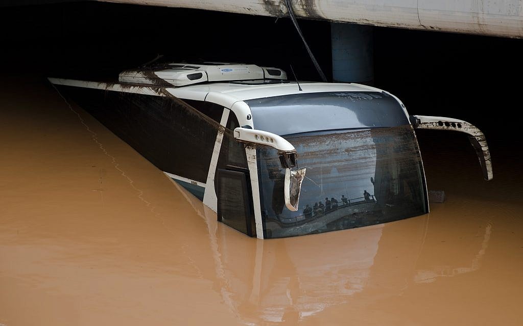 People are reflected in the front window of a flooded bus as water engulfs an interchange of a highway in Elefsina, western Athens, on Wednesday, Nov. 15, 2017. (AP Photo/Petros Giannakouris)