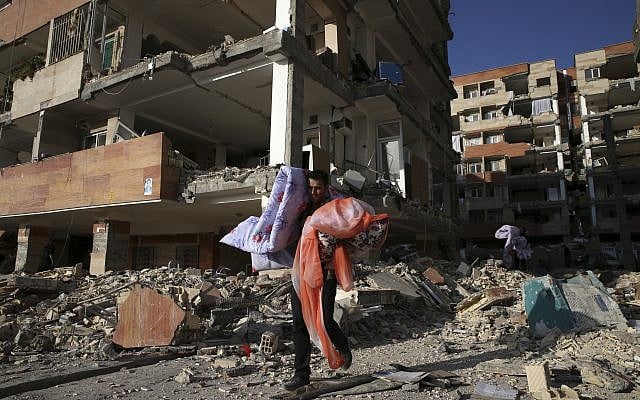 A man carries belongings of his brother's apartment damaged by an earthquake, in a compound which was built under the Mehr state-owned program, in Sarpol-e-Zahab in western Iran, November 15, 2017. (AP /Vahid Salemi) A man carries belongings of his brother's apartment damaged by an earthquake, in a compound which was built under the Mehr state-owned program, in Sarpol-e-Zahab in western Iran, November 15, 2017. (AP /Vahid Salemi)